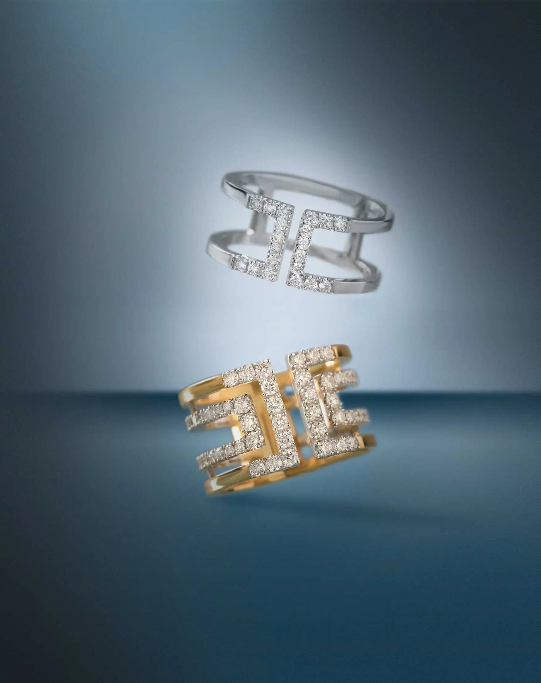 Heloise Icon and white gold Loulou Icon rings with lab-grown diamonds, floating against a blue gradient background.