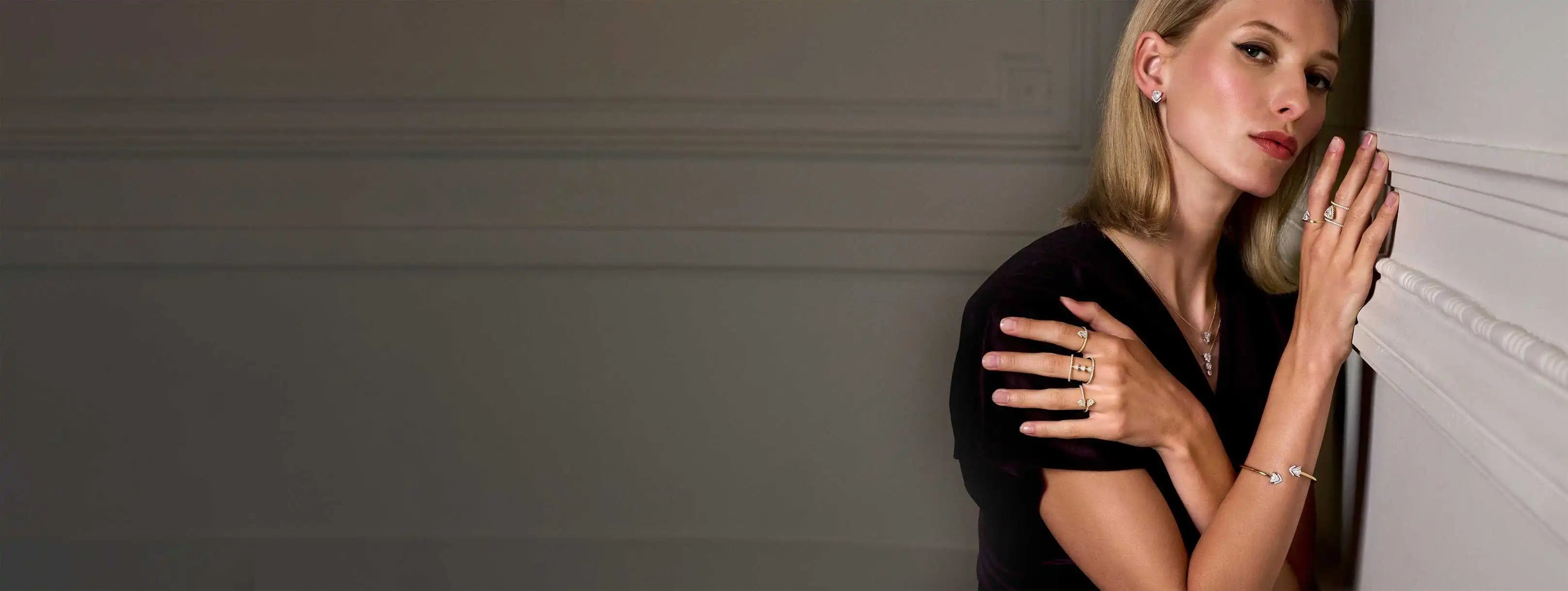 A model leaning against a white wall, stacking the Les Angles collections.