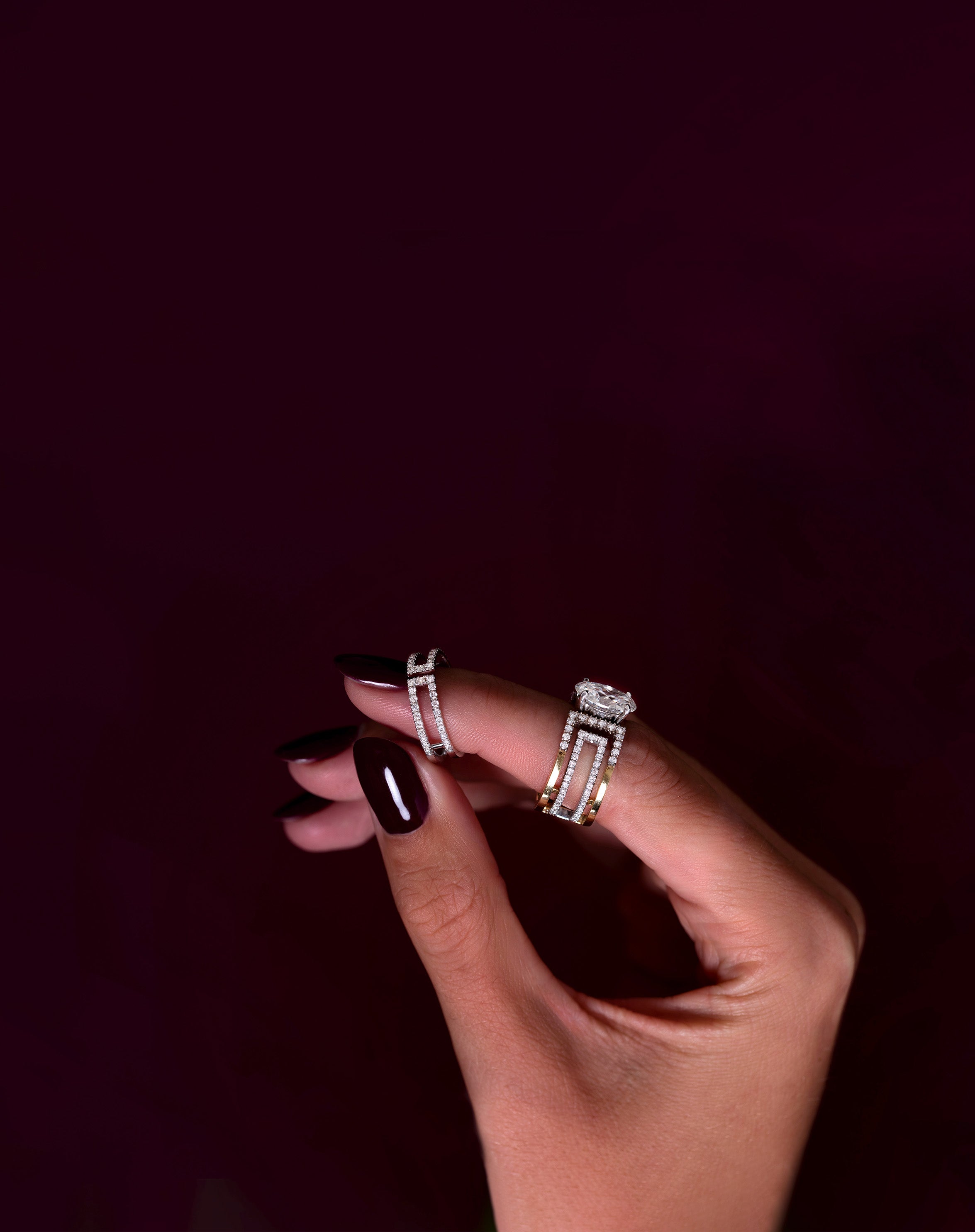 Hand cropping out holding the Loulou Petit  and wearing the Heloise Oval ring around its index finger.