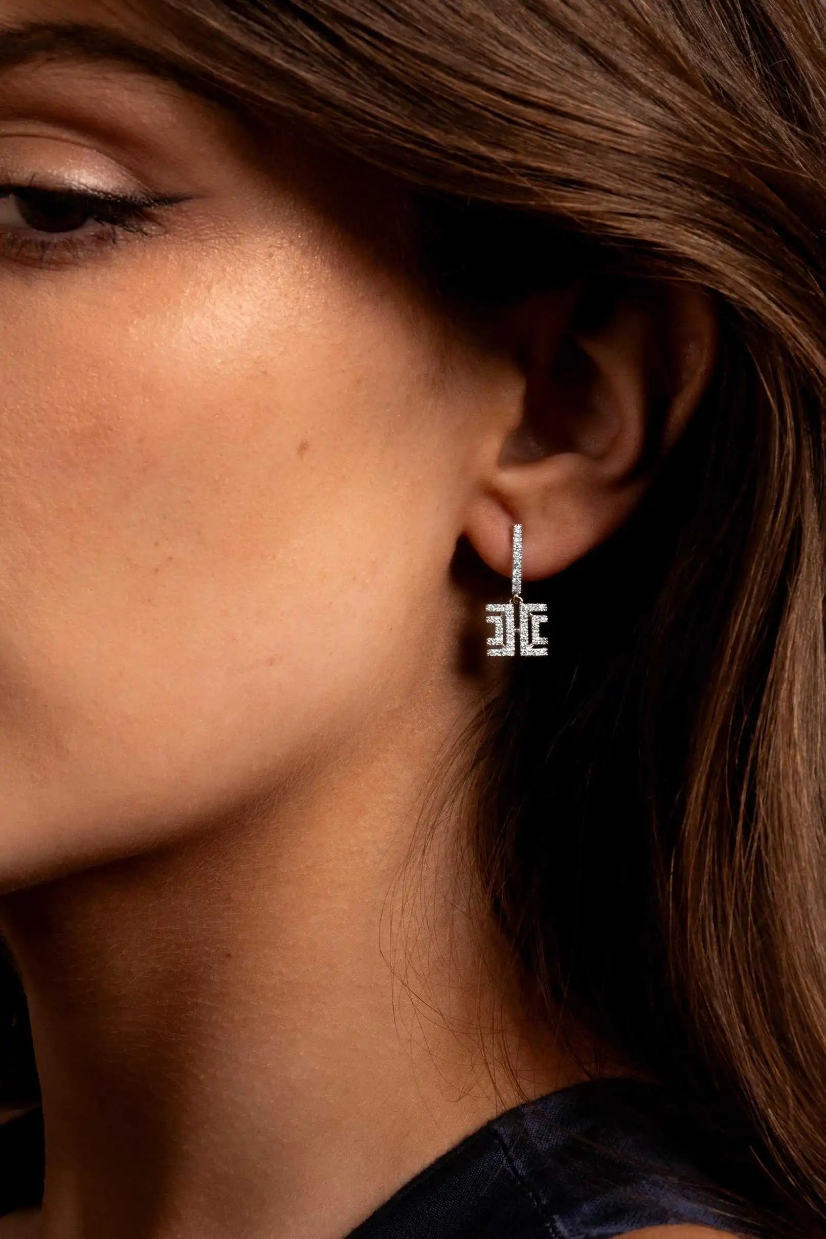 The Harper Dangler earring worn on a single model’s ear, representing the earring category.